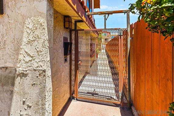 Exterior view of a building entrance with a gated walkway.
