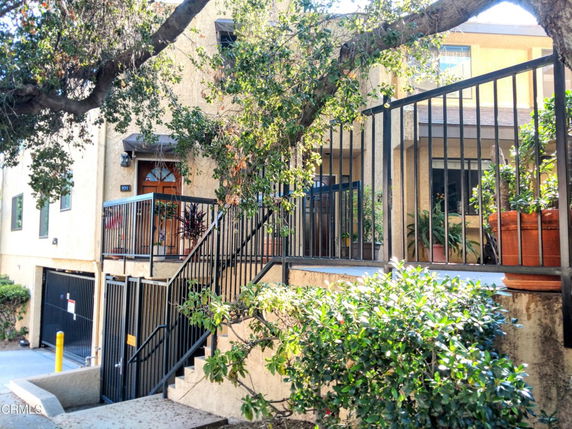 Front view of a multi-story building with an entrance and railing.