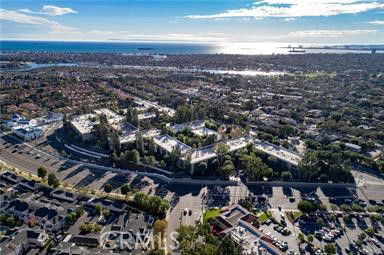 Panoramic view of a cityscape with residential and commercial buildings, a coastline, and the sea in the background.