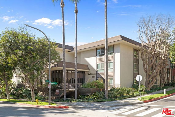 Front view of a multi-story residential building with a modern design and entrance.
