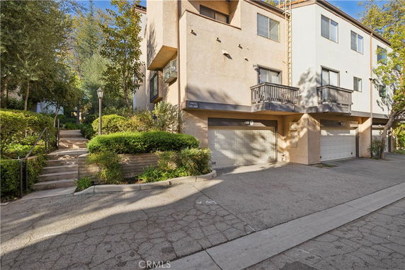 Front view of a multi-story building with garages on the ground floor.