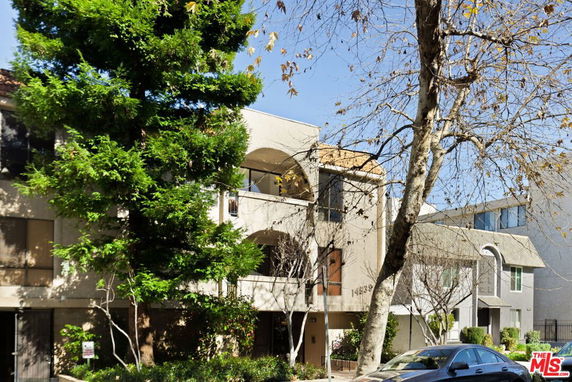 Front view of a multi-story building with balconies and large windows.