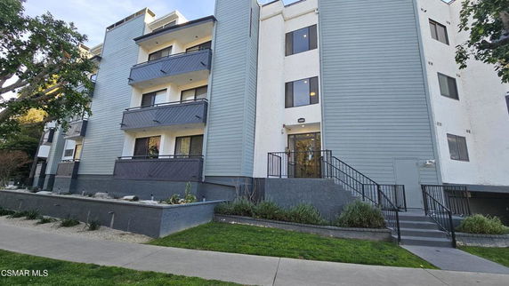 Front view of a multi-story apartment building with balconies.