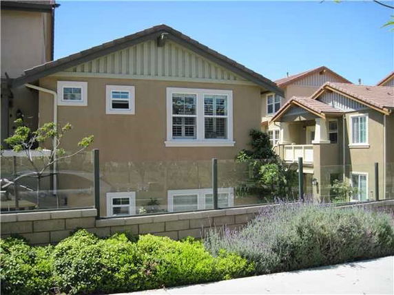 Exterior view of a two-story house with brown walls and white-trimmed windows.