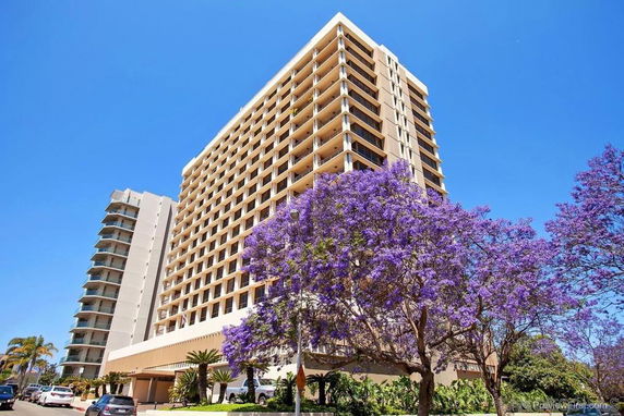 Front view of a tall residential building with multiple floors.