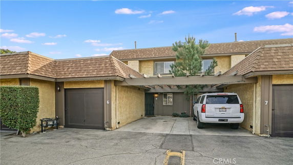 Front view of a two-story house with carport and garage.