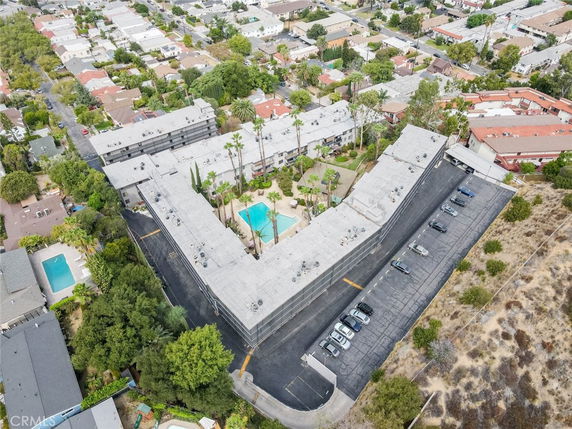 Aerial view of a residential complex with a swimming pool in a suburban area.