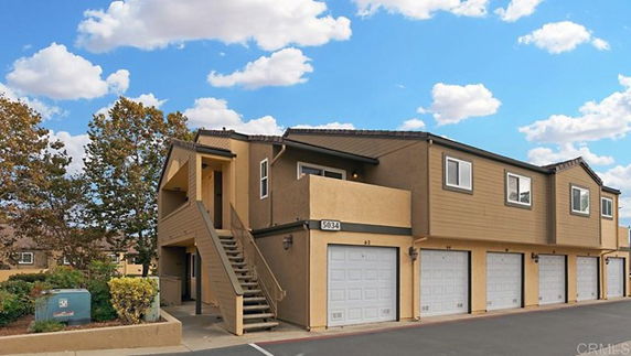 Front view of a two-story building with multiple garages on the ground level.