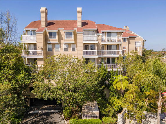 Front view of a multi-story residential building with balconies and chimneys.