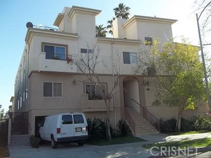Front view of a multi-story apartment building with a staircase entrance.