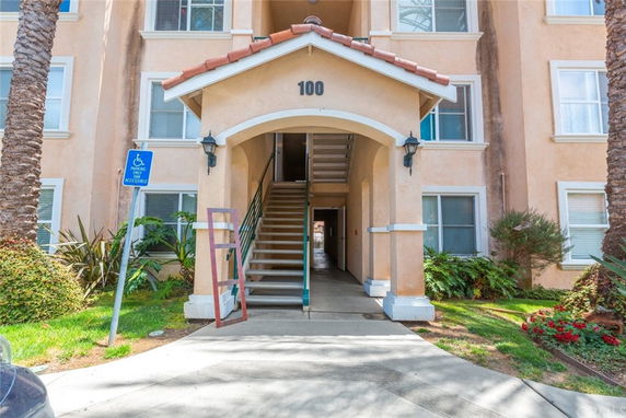 Front view of a multi-story residential building entrance with stairs.
