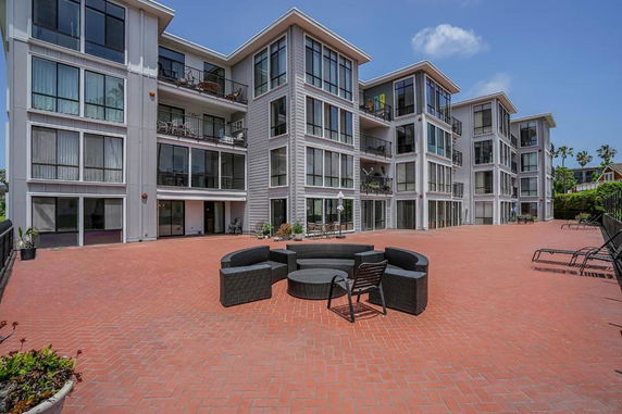 Front view of a modern multi-story apartment building with large glass windows and balconies.