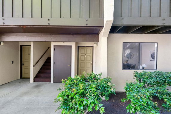 Front view of a multi-level building entrance with stairs and multiple doors.