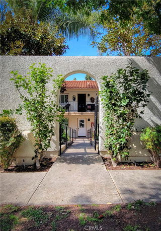 Front view of a two-story building with an archway entrance and a red-tiled roof.