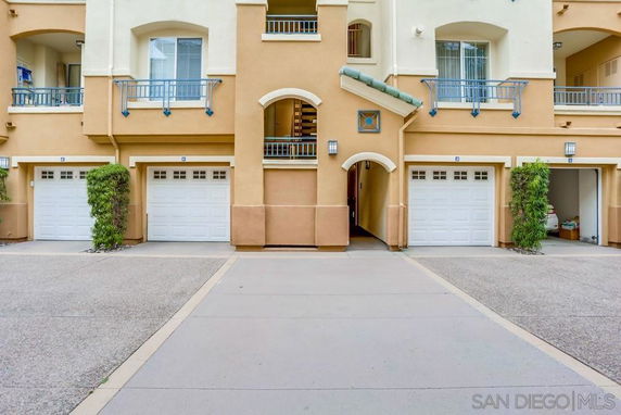 Front view of a multi-story residential building with multiple garage doors.