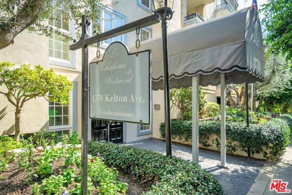 Front view of a condominium building with a sign reading 'Le Chateau at Westwood' and an awning at the entrance.