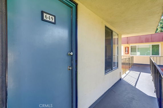 Front view of a building entrance with a blue door and windows on an upper floor.