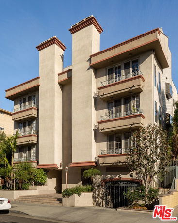 Front view of a multi-story apartment building with balconies.