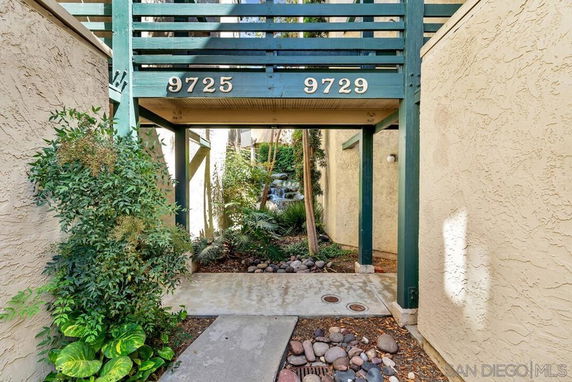 Entryway of a building with the numbers 9725 and 9729 displayed above.