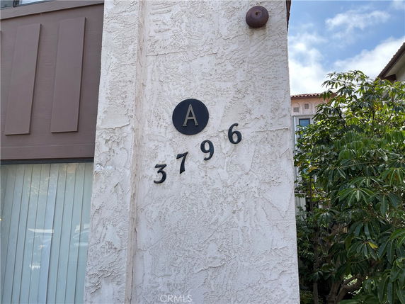 Front view of a building showing the address number 3796 with a textured wall.