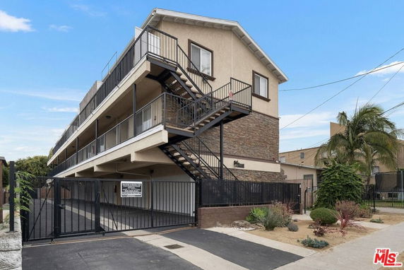 Front view of a multi-story residential building with outdoor staircases.