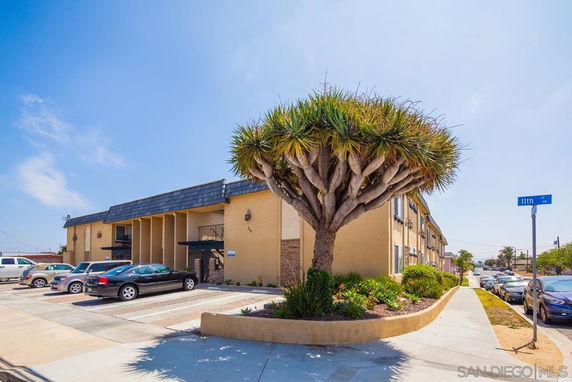 Front view of a two-story building with a parking area in front.