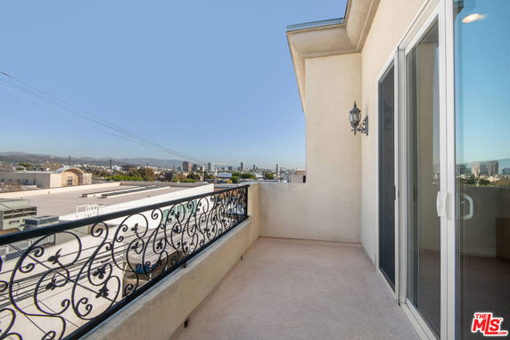 Balcony with decorative railing and city view.
