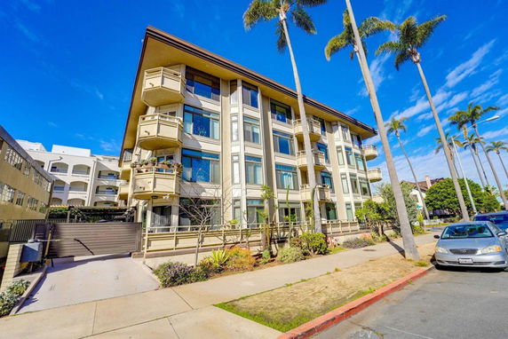 Front view of a multi-story apartment building with balconies.
