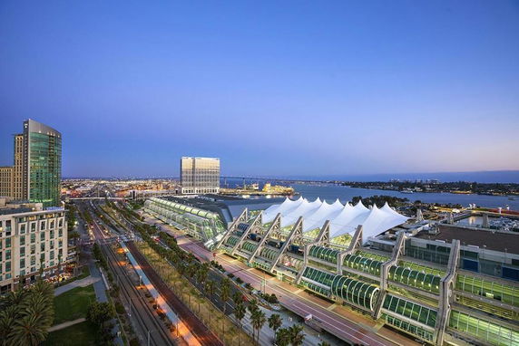 Aerial view of urban buildings near a waterfront with a prominent convention center.