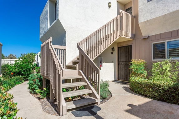 Front view of a multi-story building entry with an exterior staircase.