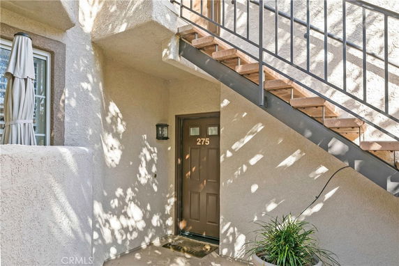 Entryway to a residential unit with labeled door under stairs.