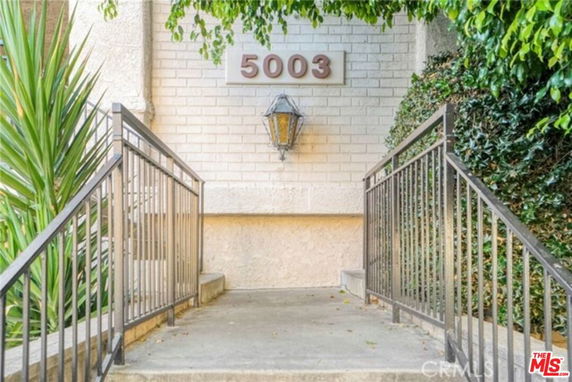 Front view of a building entrance with stairs and railings.