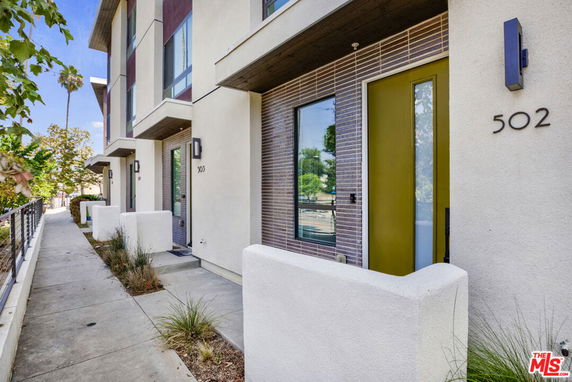 Front view of a modern multi-story building with unique entrance designs.