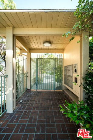 Entrance area of a building with a gated doorway and mailboxes.