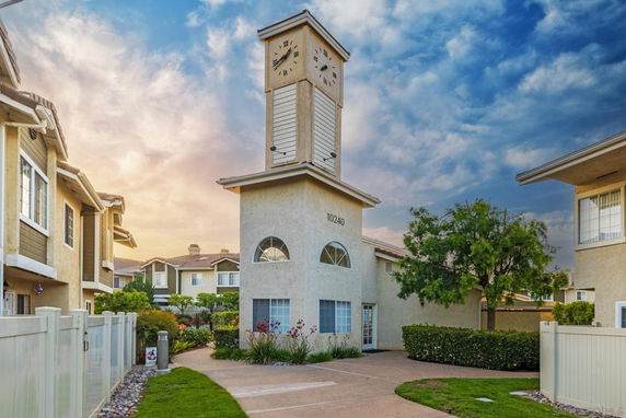 Front view of a building with a prominent clock tower in a residential complex.