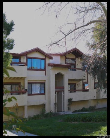 Front view of a multi-story house with a distinctive roof design.