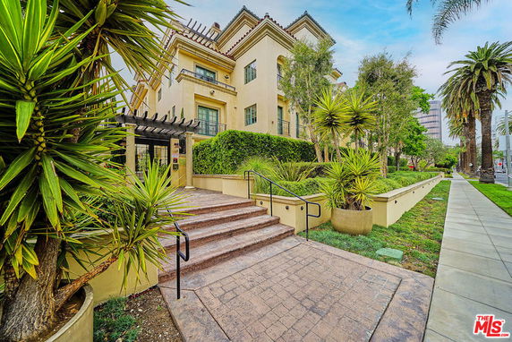 Front view of a multi-story building with a landscaped entrance.