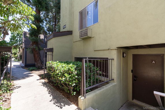 Front view of a building entrance with an exterior air conditioning unit.