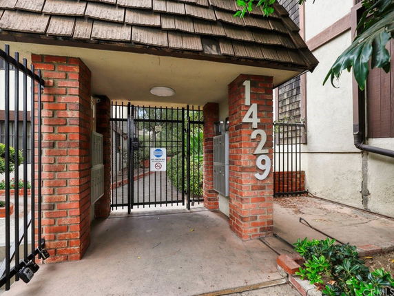 Front view of a building entrance with a brick structure and gated entry.