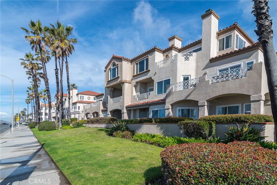 Front view of a multi-story building with balconies and arched windows.