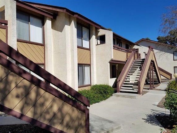 Front view of a two-story residential building with external staircases.