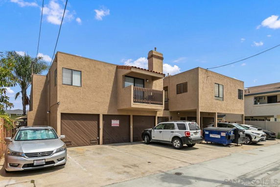 Front view of a two-story building with attached garage and balconies.