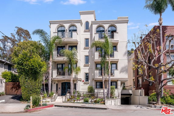 Front view of a multi-story apartment building with balconies.