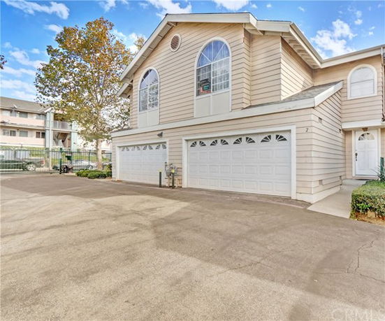 Front view of a multi-story house with double garage doors.