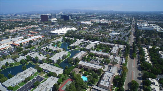 Aerial panoramic view of urban residential and commercial areas with multiple buildings and roads.