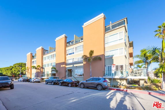 Front view of a multi-story building with large windows and balconies.