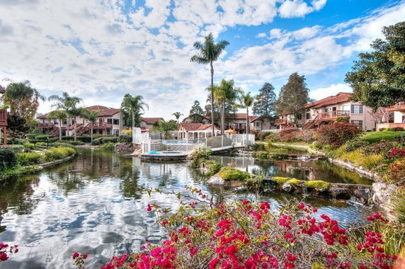 Residential buildings with a pond and landscaped gardens.