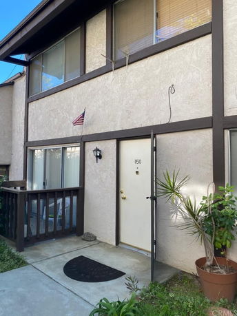 Front view of a townhouse with two stories and a small porch area.