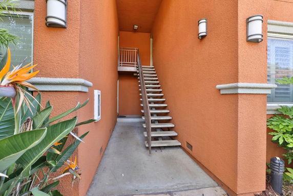 Front view of a building entrance with stairs and orange walls.
