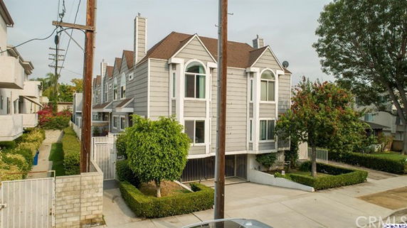 Front view of a two-story house with large windows and a gable roof.